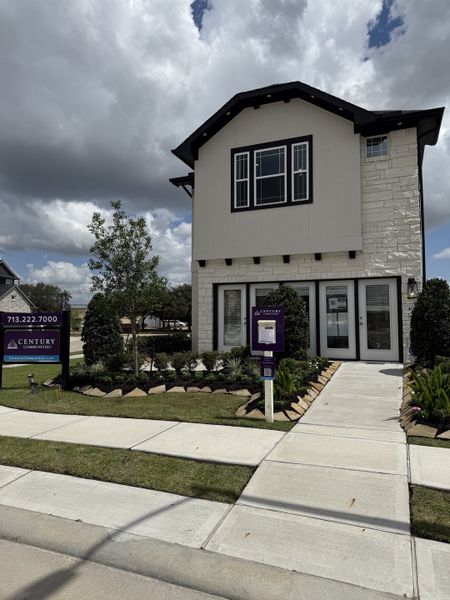 Charming modern home with stone accents and manicured lawn in Park Hill Villas by Century Communities (Stafford, TX).