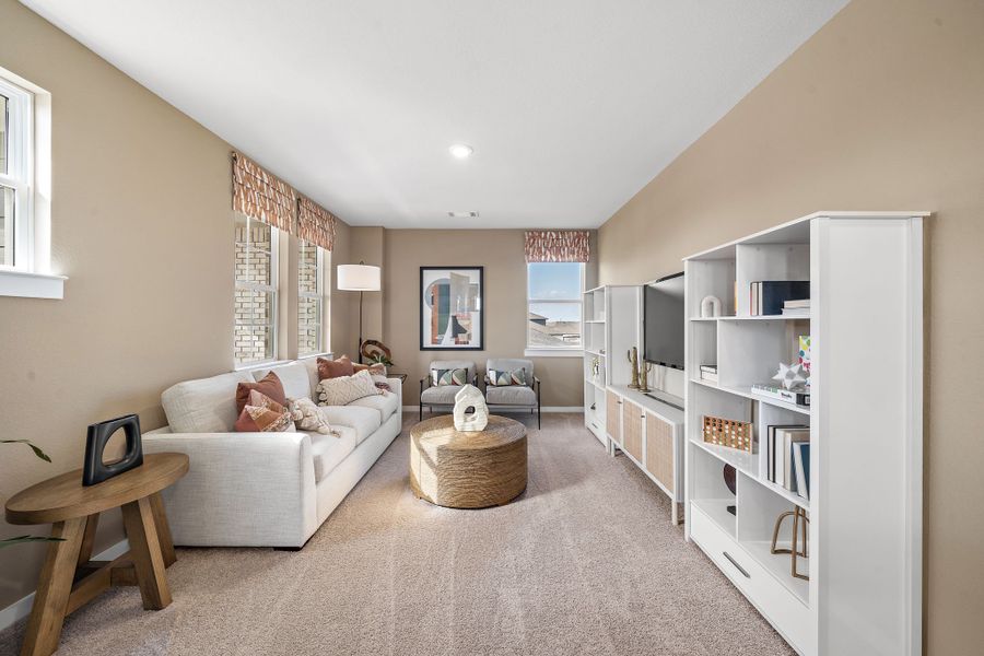 A living room with a white couch and a white bookcase.