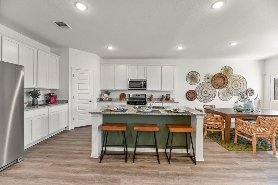 A kitchen with white cabinets and a table with plates on it.