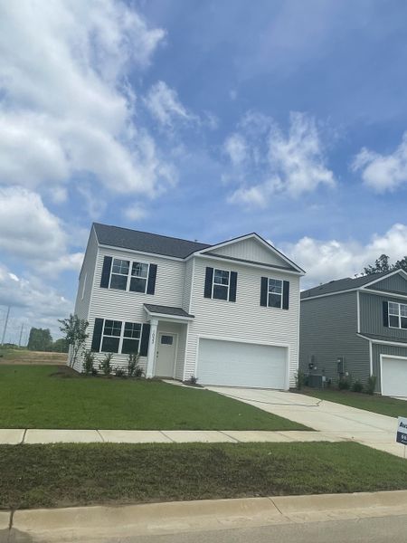 A modern two-story home with a spacious driveway and lawn in Pineview North by D.R. Horton (Summerville, SC).