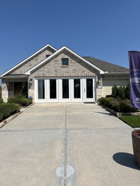 Charming brick home with a clean driveway and landscaped yard in Marvida by M/I Homes (Cypress, TX).