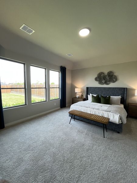 A spacious bedroom with plush carpet, large windows, a stylish bed, and modern decor, offering a bright and cozy retreat. A spacious bedroom with plush carpet, large windows, a stylish bed, and modern decor, offering a bright and cozy retreat.