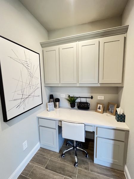 A modern home office nook with sleek cabinetry, abstract artwork, and a comfortable rolling chair. A modern home office nook with sleek cabinetry, abstract artwork, and a comfortable rolling chair.