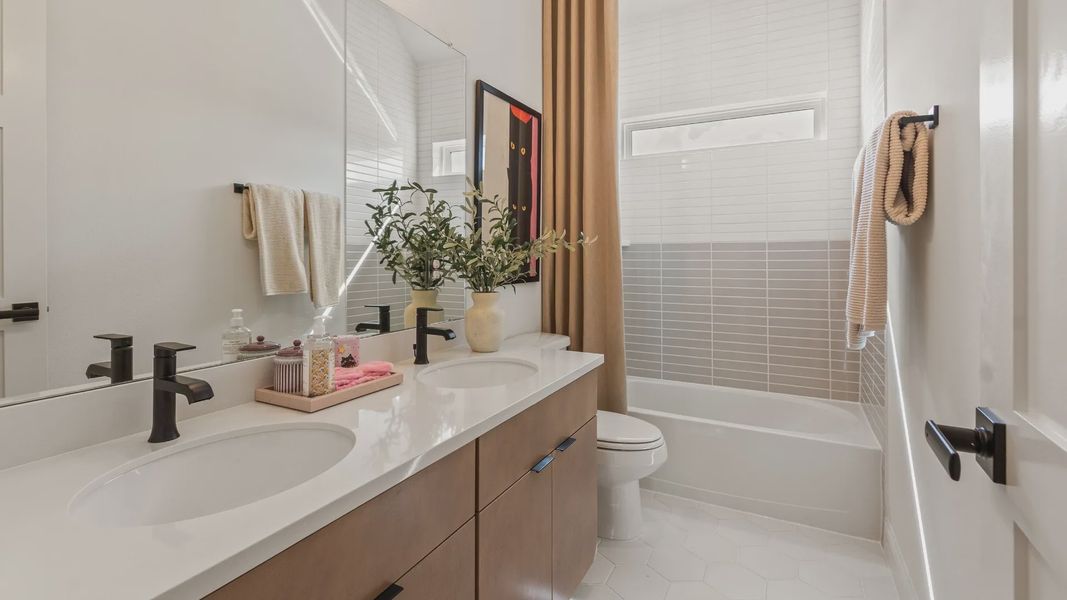 Experience elegance with custom wood vanity and exquisite tile accents in River Ranch.