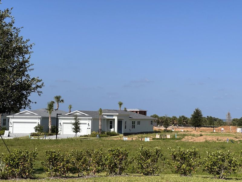 A modern white home with pristine lawns in Cresswind at Lake Harris by Kolter Homes (Tavares, FL).