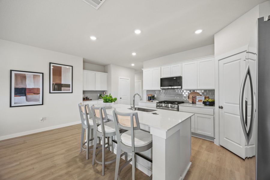 A kitchen with white cabinets.