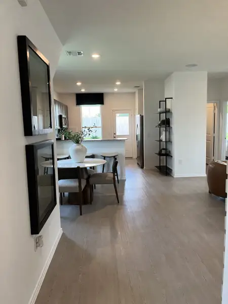 An inviting kitchen and dining area with light wood floors, a modern table, and sleek cabinetry.