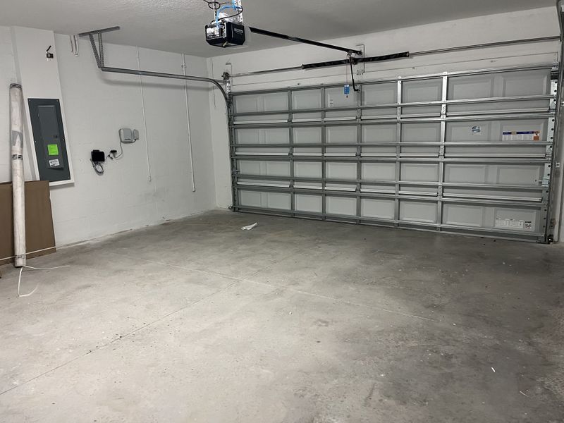 A spacious, modern garage with clean concrete floors and a large metal door. Ideal for storage or parking needs. A spacious, modern garage with clean concrete floors and a large metal door. Ideal for storage or parking needs.