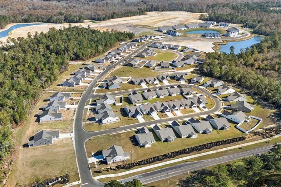 Aerial view of the Lakes at Riverbend Single Family Homes community in Navassa, NC, showing layout and nearby surroundings (Image 1).