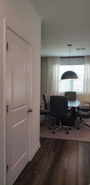 A modern dining area with sleek chairs, a round table, and a large pendant light, complemented by soft natural light. A modern dining area with sleek chairs, a round table, and a large pendant light, complemented by soft natural light.