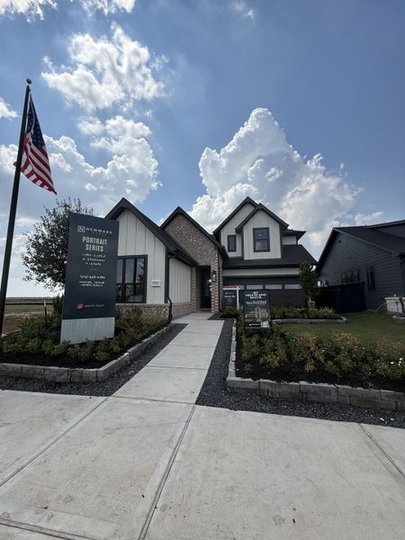 A modern home with a brick and siding exterior in Austin Point by Newmark Homes, Richmond, TX.