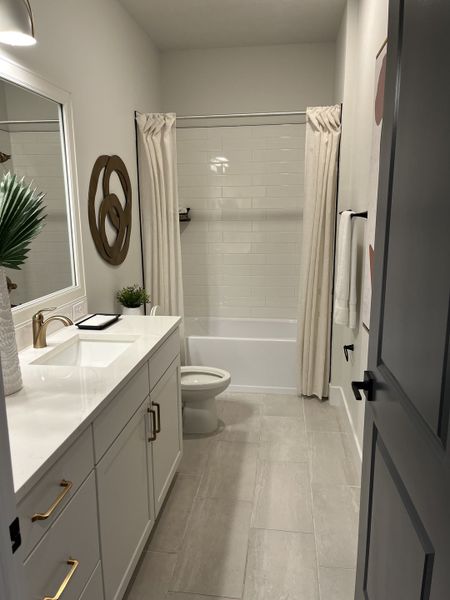 A chic bathroom with sleek white cabinets, modern fixtures, and a classic white-tiled shower for a fresh look.