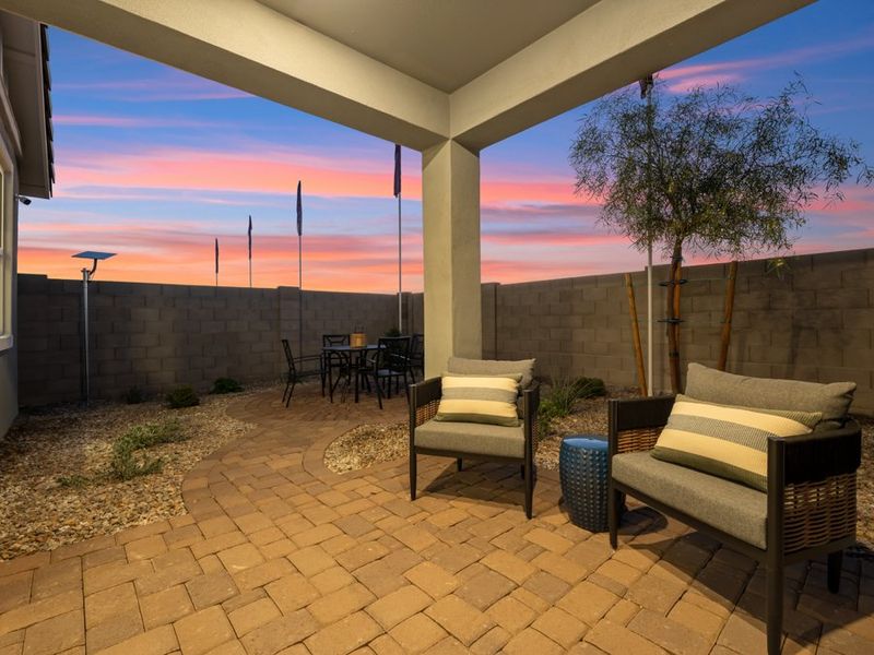 A patio with chairs and a table.