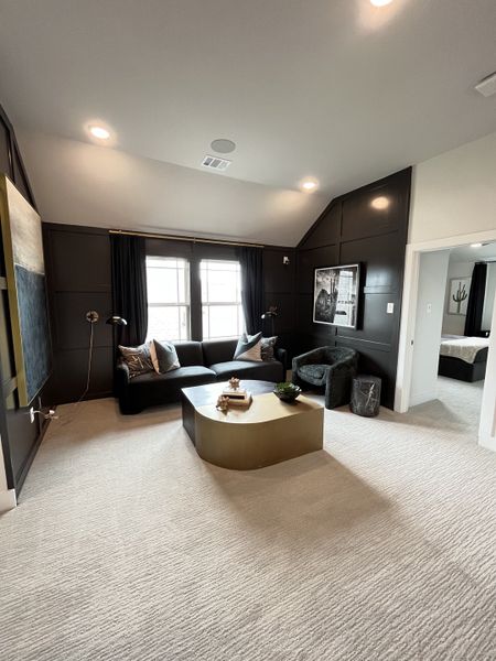 A cozy living space with dark accent walls, soft carpeting, and modern furnishings, perfect for relaxation. A cozy living space with dark accent walls, soft carpeting, and modern furnishings, perfect for relaxation.