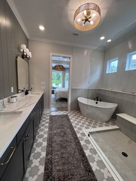 A chic bathroom featuring a freestanding tub, patterned tiles, dual sinks, and stylish lighting, creating a spa-like retreat. A chic bathroom featuring a freestanding tub, patterned tiles, dual sinks, and stylish lighting, creating a spa-like retreat.