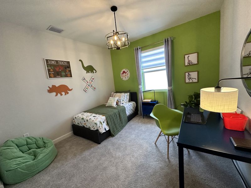 A playful dinosaur-themed bedroom with vibrant green accents and cozy decor. Perfect for a child's creative space.