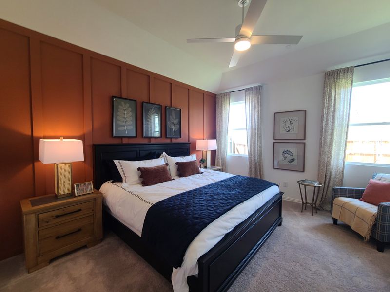 A cozy bedroom with an orange accent wall, elegant decor, and a stylish ceiling fan. A cozy bedroom with an orange accent wall, elegant decor, and a stylish ceiling fan.