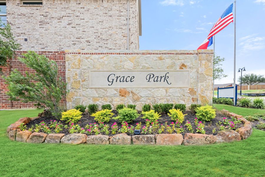 Grace Park neighborhood entrance sign on stone wall with landscaped flower bed and American flag in background Grace Park neighborhood entrance sign on stone wall with landscaped flower bed and American flag in background