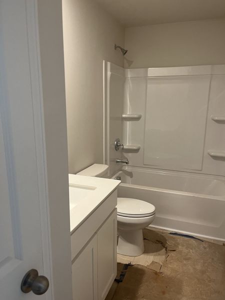 A compact bathroom featuring a white vanity, bathtub, and neutral walls, offering simplicity and functionality. A compact bathroom featuring a white vanity, bathtub, and neutral walls, offering simplicity and functionality.