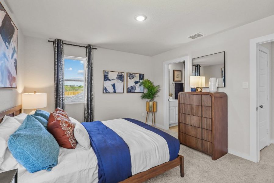 A bedroom with a bed and a dresser.