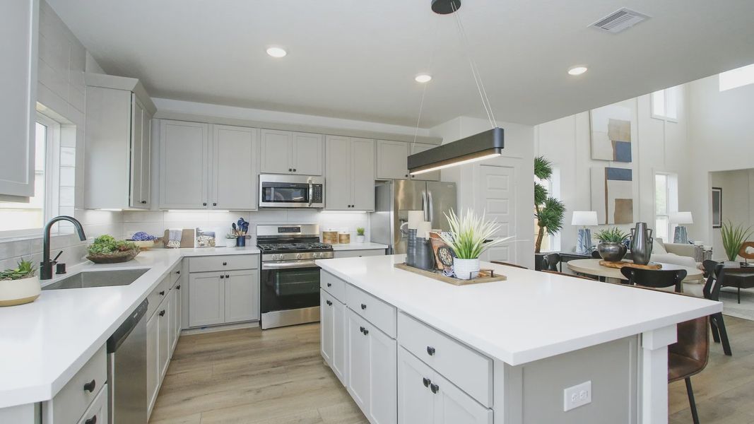 Luxurious Pinehurst kitchen boasts sleek cabinetry, expansive island, and stainless steel appliances.