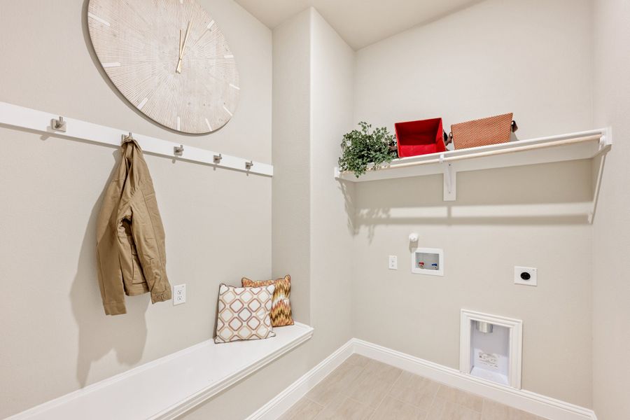 Mudroom with coat hooks, built-in bench, wall shelf, and pet door in neutral tones