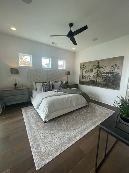 A serene bedroom with a cozy bed, elegant nightstands, and a large wall art piece, complemented by a stylish area rug. A serene bedroom with a cozy bed, elegant nightstands, and a large wall art piece, complemented by a stylish area rug.