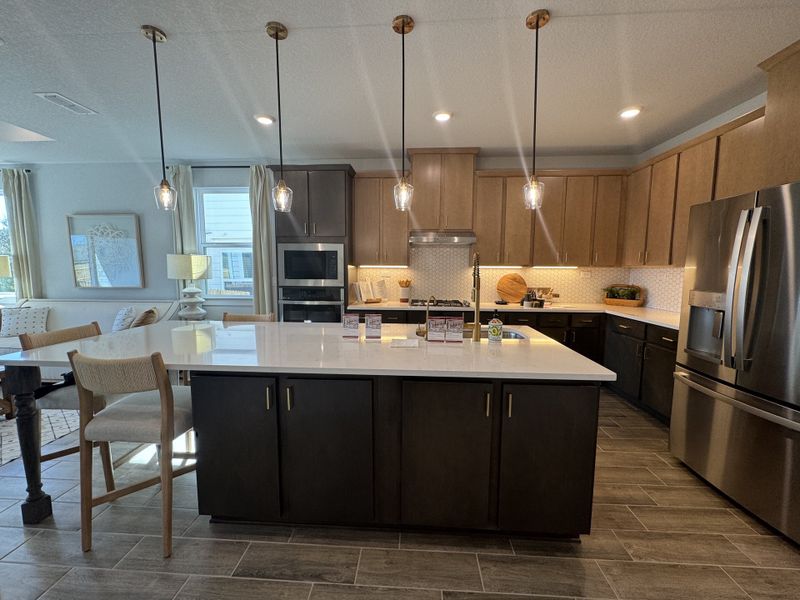 A modern kitchen with sleek cabinetry, stainless appliances, and elegant pendant lighting over a spacious island. A modern kitchen with sleek cabinetry, stainless appliances, and elegant pendant lighting over a spacious island.