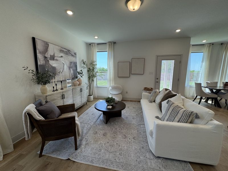 A cozy living room featuring a white sofa, modern art, and abundant natural light from large windows and elegant decor. A cozy living room featuring a white sofa, modern art, and abundant natural light from large windows and elegant decor.