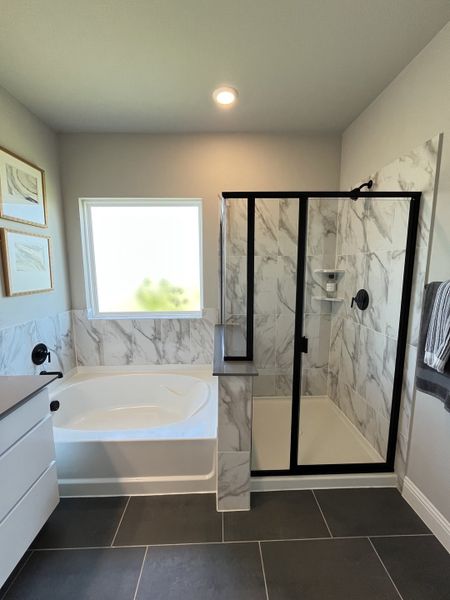 A luxurious bathroom featuring marble tiles, a sleek glass shower, and a relaxing bathtub with elegant fixtures. A luxurious bathroom featuring marble tiles, a sleek glass shower, and a relaxing bathtub with elegant fixtures.