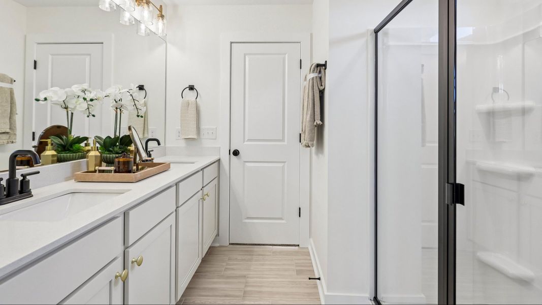 Primary bathroom with dual vanity and glass enclosed