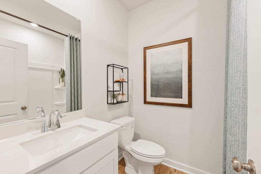 A bathroom with a sink toilet and a mirror. A bathroom with a sink toilet and a mirror.