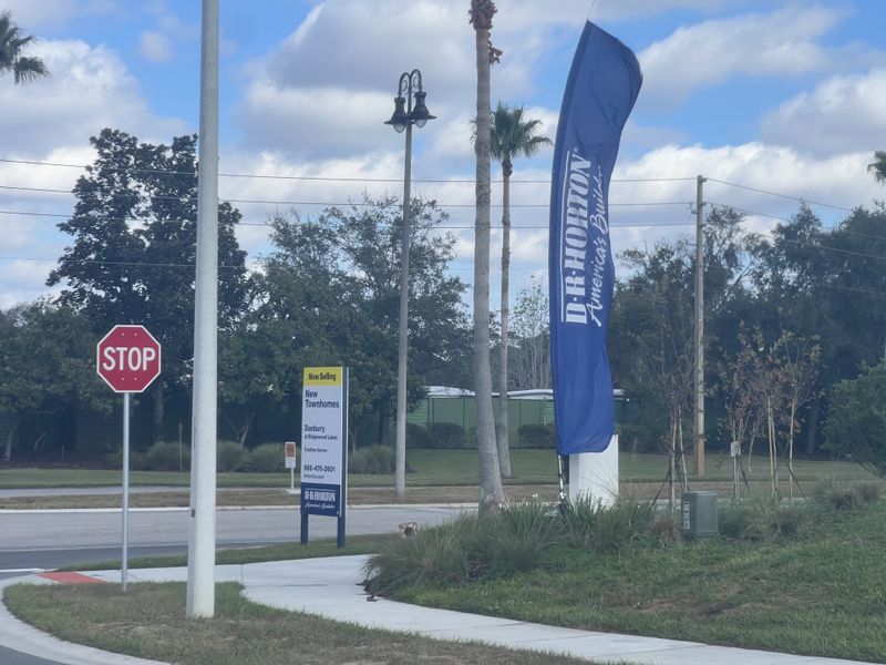 A welcoming entrance with D.R. Horton signage at Danbury at Ridgewood Lakes in Davenport, FL, surrounded by lush greenery.