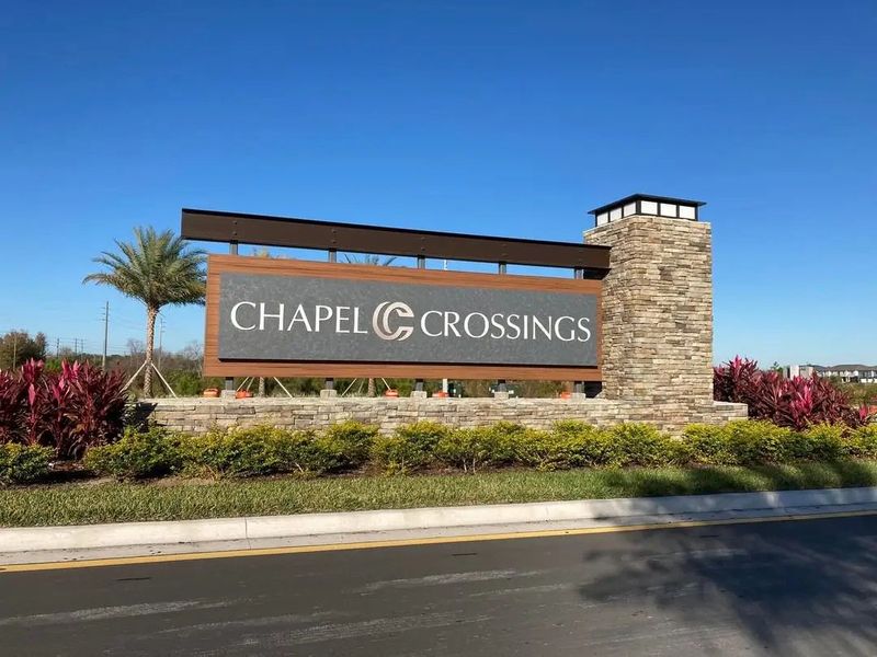Main entrance to the Chapel Crossings master-planned community in Wesley Chapel, FL, featuring its landmark signage (Image 8). Main entrance to the Chapel Crossings master-planned community in Wesley Chapel, FL, featuring its landmark signage (Image 8).