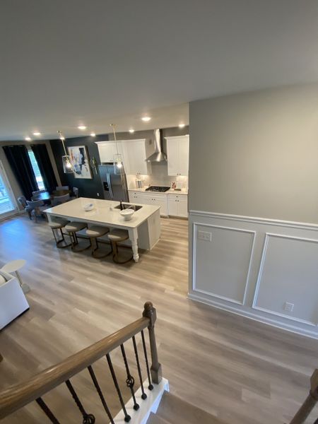 An open-concept kitchen with sleek white cabinetry, a spacious island, and elegant lighting creates a modern, inviting atmosphere.