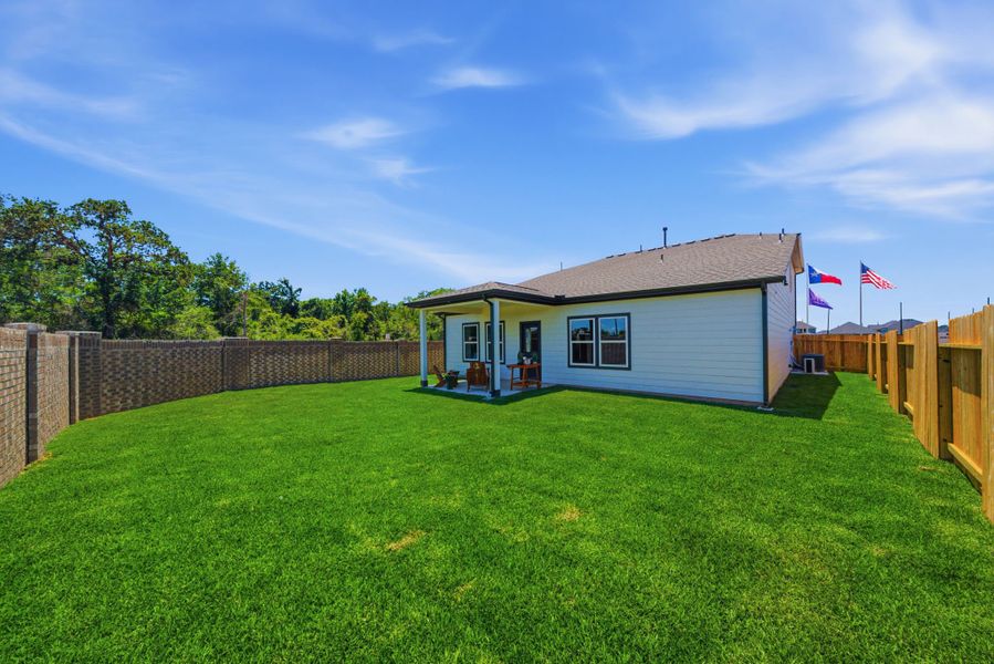 A small house with a fence and grass in front of it. A small house with a fence and grass in front of it.