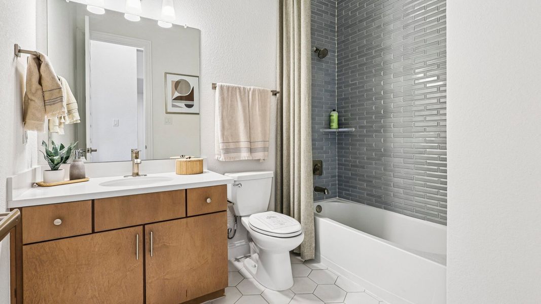 Sleek bathroom features modern vanity, luxurious tiling, and refined finishes in Sunterra community. Sleek bathroom features modern vanity, luxurious tiling, and refined finishes in Sunterra community.