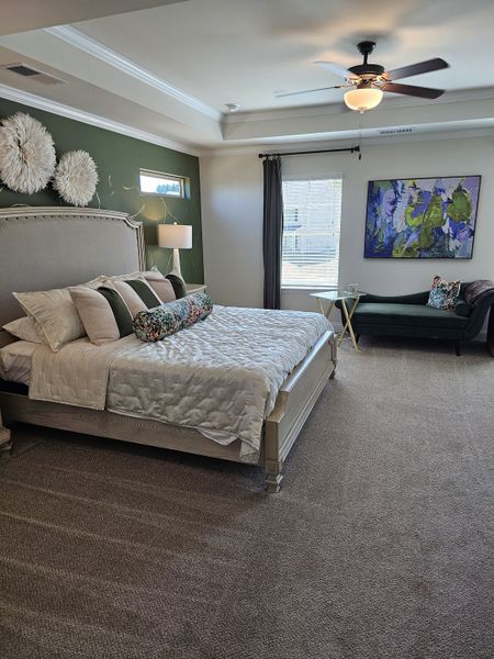 A spacious bedroom with plush carpeting, a statement wall, and elegant decor creating a serene and inviting atmosphere.