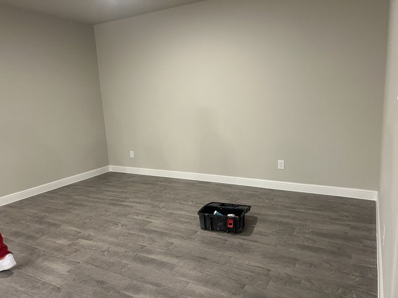 A spacious room with gray-toned wood flooring and neutral walls, perfect for personalized design and decor. A spacious room with gray-toned wood flooring and neutral walls, perfect for personalized design and decor.