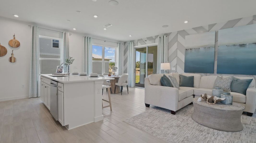 Open kitchen and living space at DRB Homes with large windows for natural light