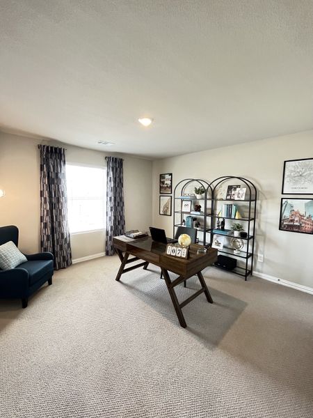 A cozy home office featuring a wooden desk, cozy chair, and modern bookshelf with decorative accents.
