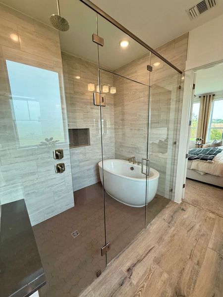 A modern bathroom featuring a sleek glass shower, a freestanding tub, and elegant tile accents for a luxurious escape.