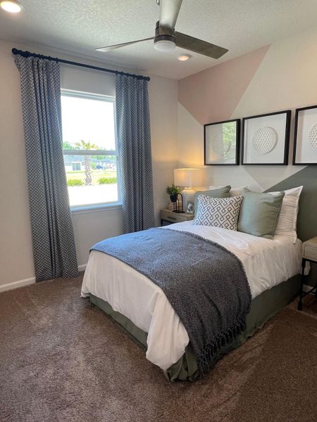 A cozy bedroom featuring modern art, elegant bedding, and natural light filtering through stylish curtains.