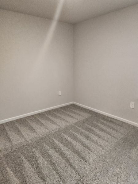 A freshly carpeted room with soft gray tones, crisp white trim, and a subtle play of light creating a serene atmosphere. A freshly carpeted room with soft gray tones, crisp white trim, and a subtle play of light creating a serene atmosphere.