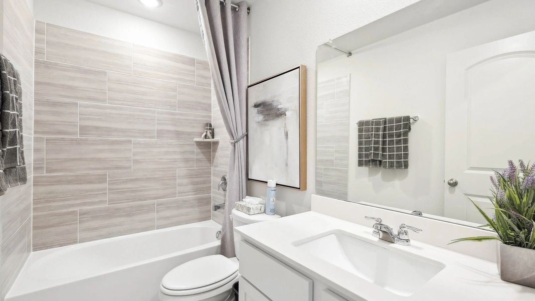 Featuring luxurious beige tiles and sleek fixtures, this Still Water Lake Estates bathroom exudes modern elegance.