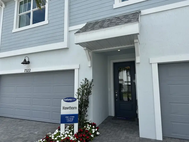 Charming modern home with gray siding and double garage in Forest by Mattamy Homes, Lake Worth, FL.