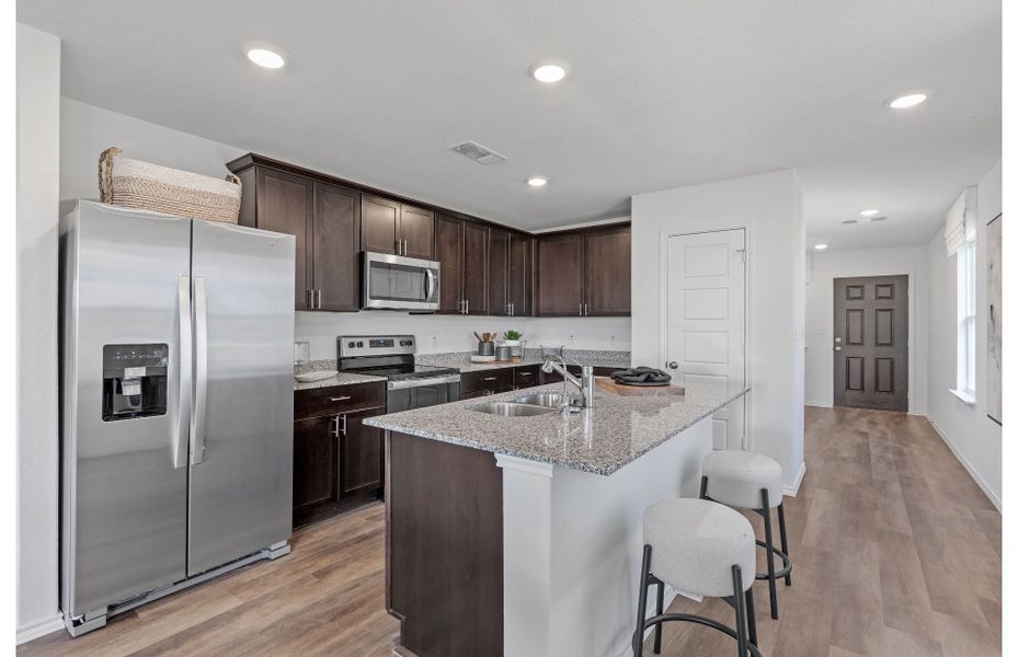 Open floor plan kitchen with cabinets and large island in new homes at Vista Real in Converse, TX Open floor plan kitchen with cabinets and large island in new homes at Vista Real in Converse, TX