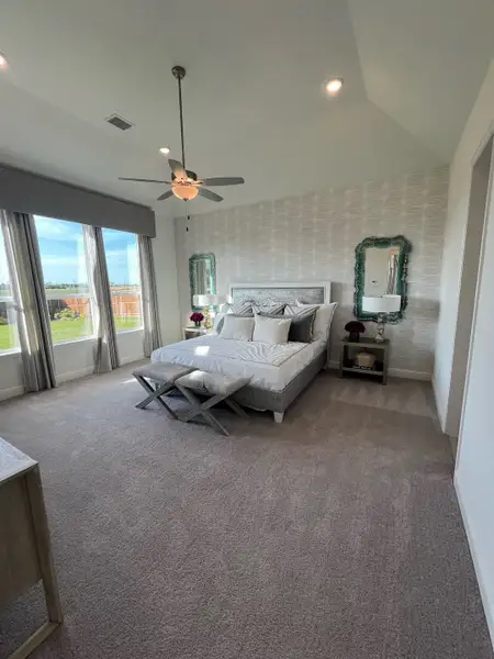 Spacious bedroom with elegant decor, plush carpeting, and large windows offering natural light. Spacious bedroom with elegant decor, plush carpeting, and large windows offering natural light.