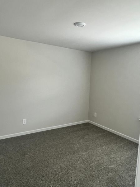 A cozy room with plush gray carpeting, soft white walls, and recessed lighting for a serene atmosphere. A cozy room with plush gray carpeting, soft white walls, and recessed lighting for a serene atmosphere.