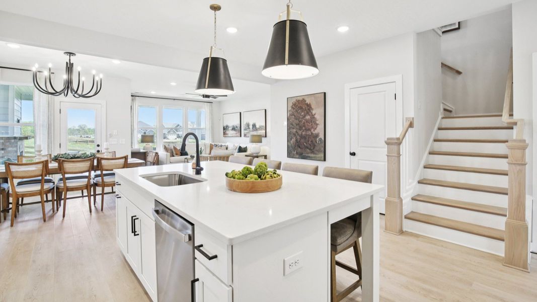 View from kitchen of dining area, gathering room, and staircase to second floor